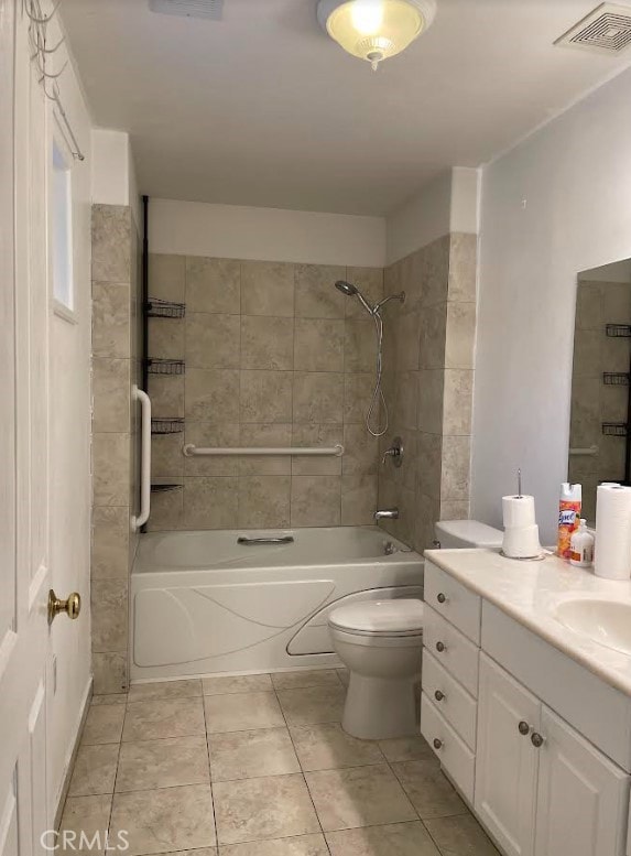 full bathroom featuring tiled shower / bath, vanity, toilet, and tile patterned flooring