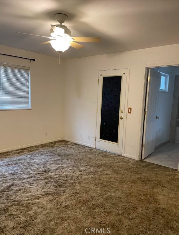 carpeted spare room with ceiling fan