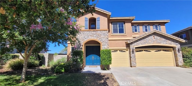 view of front of property with an attached garage, stone siding, concrete driveway, and stucco siding