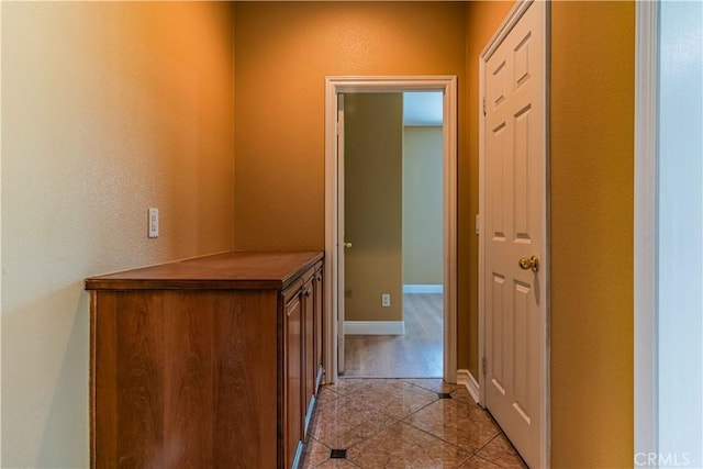 hallway with baseboards and light tile patterned floors