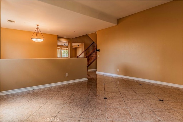 spare room featuring ceiling fan, stairway, visible vents, and baseboards