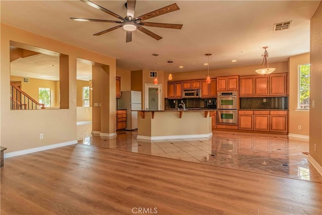 living room featuring light wood-style flooring, visible vents, and baseboards