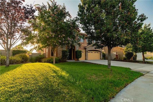 obstructed view of property with stone siding, concrete driveway, a front lawn, and stucco siding