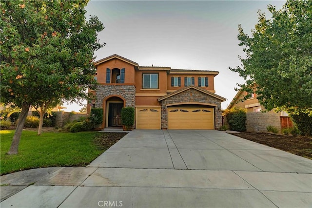 view of front of property featuring an attached garage, fence, driveway, stucco siding, and a front lawn