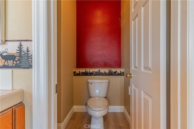 bathroom featuring toilet, baseboards, and wood finished floors