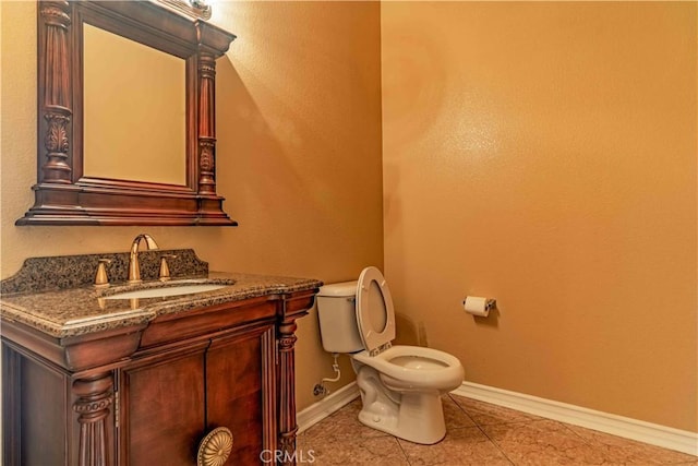 bathroom with vanity, tile patterned flooring, toilet, and baseboards