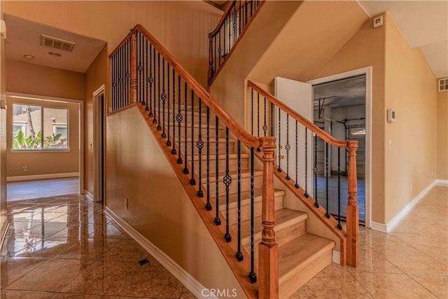 stairway featuring visible vents and baseboards