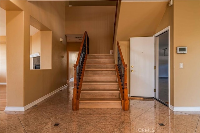 stairway featuring visible vents and baseboards