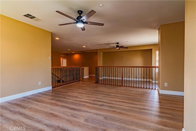 empty room featuring recessed lighting, visible vents, baseboards, and wood finished floors