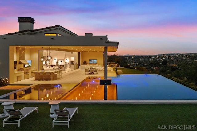 exterior space featuring a yard, exterior kitchen, and a patio