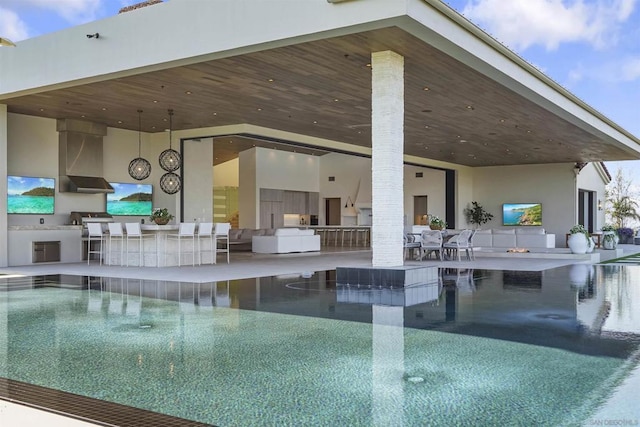 view of pool with a patio, area for grilling, and an outdoor bar