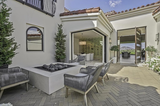 view of patio with an outdoor living space with a fire pit