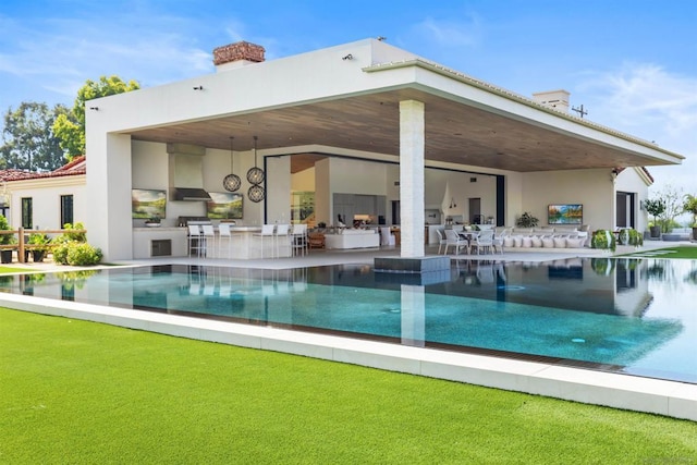 view of pool with exterior kitchen and a patio