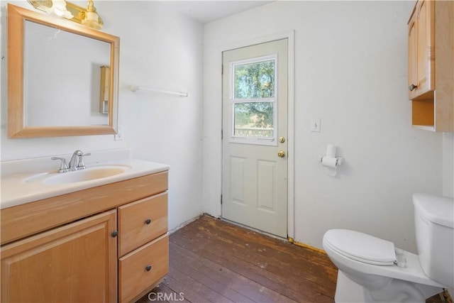 bathroom with hardwood / wood-style flooring, vanity, and toilet