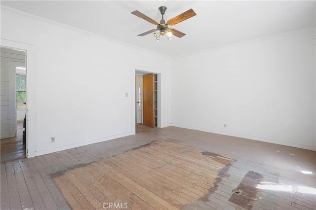 empty room with wood-type flooring, ornamental molding, and ceiling fan