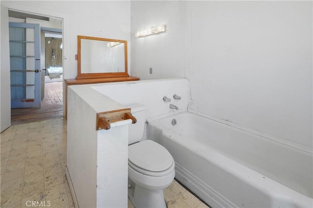 bathroom featuring a tub and toilet