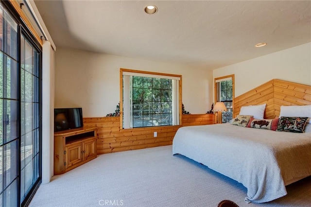 bedroom with carpet flooring and wood walls