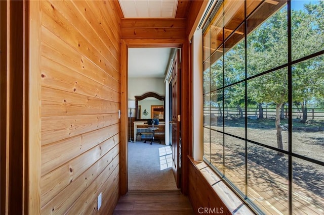 corridor featuring hardwood / wood-style flooring and wood walls