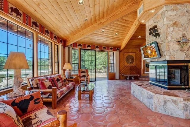 living room featuring lofted ceiling with beams, wood ceiling, a fireplace, and a wealth of natural light