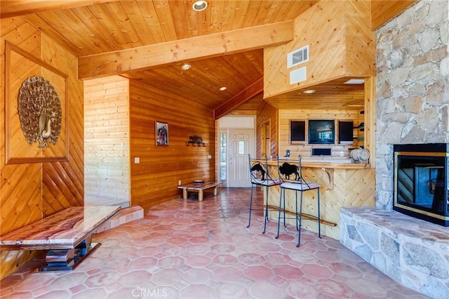 kitchen with wooden walls, a breakfast bar, beamed ceiling, and wooden ceiling