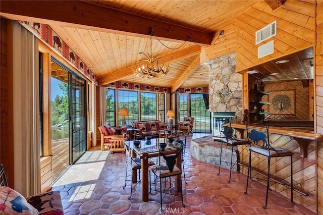 sunroom with a fireplace, vaulted ceiling with beams, a chandelier, and wood ceiling