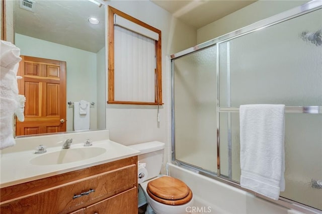 full bathroom with vanity, toilet, and combined bath / shower with glass door