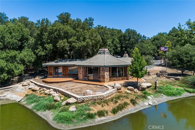 rear view of property with a deck with water view