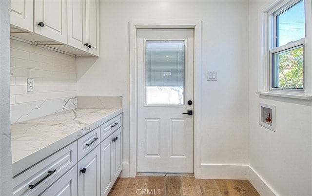 interior space featuring cabinets, hookup for a washing machine, and light wood-type flooring