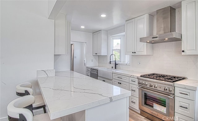 kitchen featuring white cabinets, wall chimney exhaust hood, stainless steel stove, and a breakfast bar