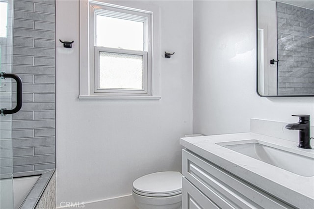 bathroom featuring vanity, toilet, and a shower with shower door