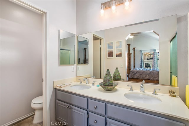 bathroom with toilet and double sink vanity