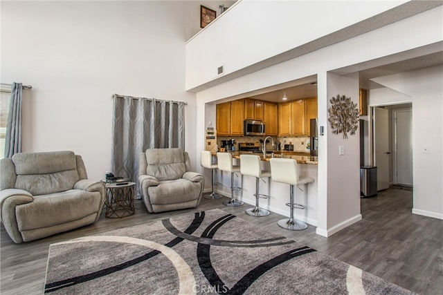 living room with hardwood / wood-style flooring and a towering ceiling