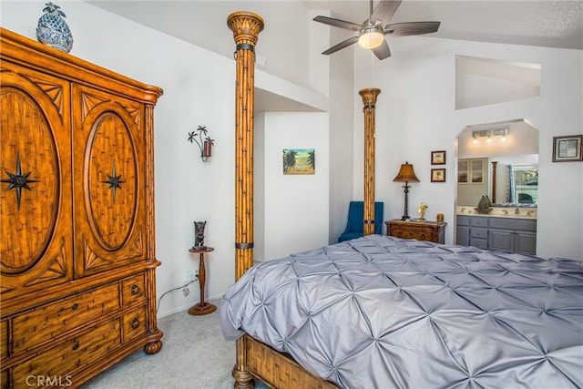 bedroom featuring ensuite bath, carpet, a textured ceiling, lofted ceiling, and ceiling fan