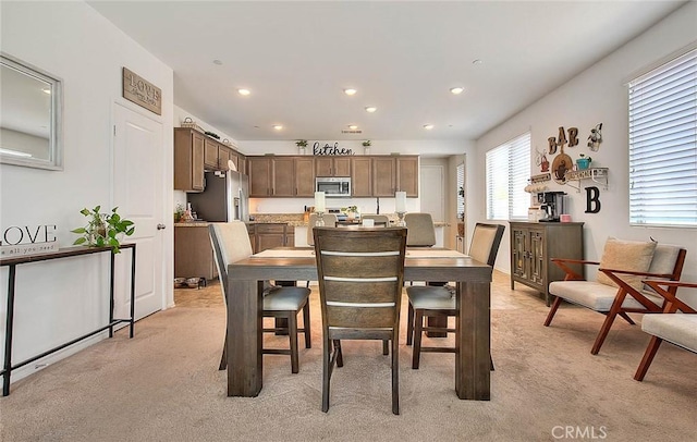 dining area featuring light carpet