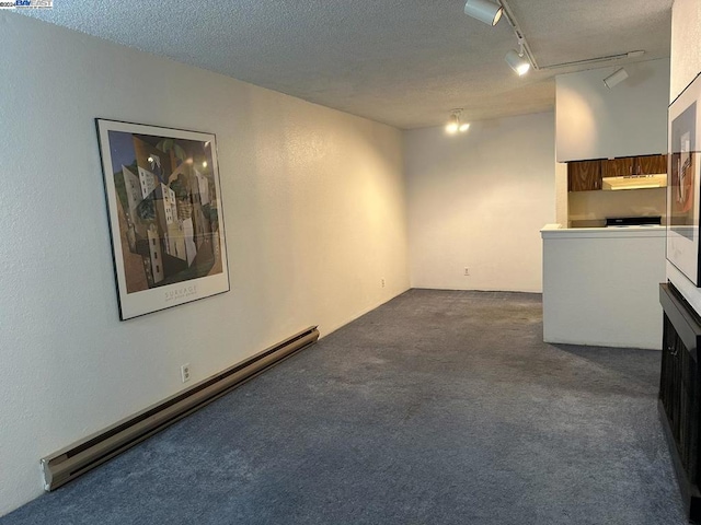 unfurnished room with track lighting, a textured ceiling, a baseboard heating unit, and dark colored carpet