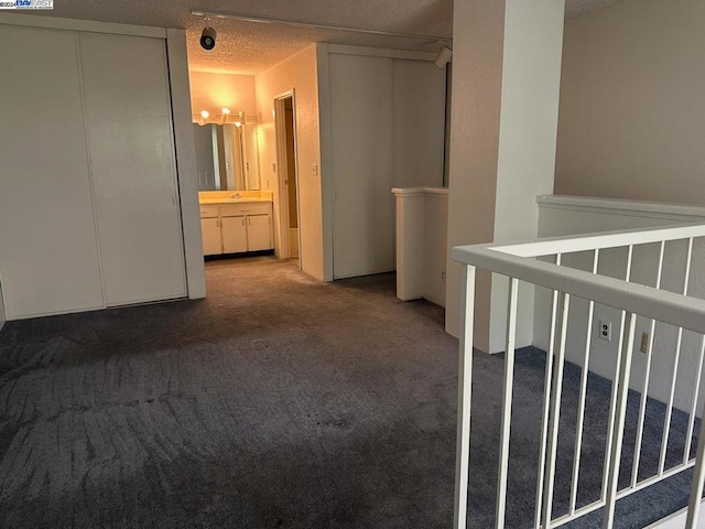 interior space with a textured ceiling and carpet floors