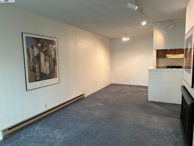 basement featuring track lighting, a textured ceiling, dark carpet, and a baseboard radiator