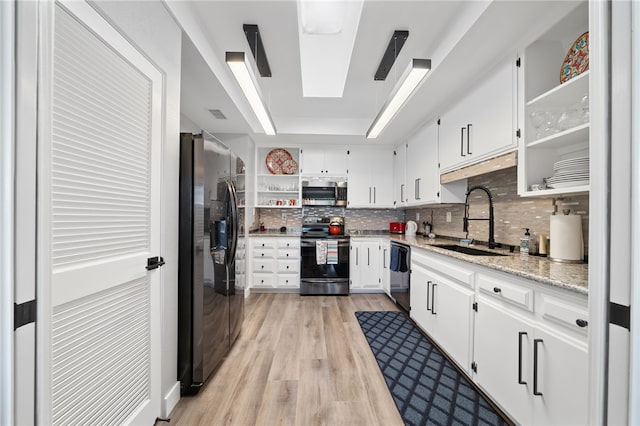 kitchen with light hardwood / wood-style flooring, stainless steel appliances, white cabinetry, and sink