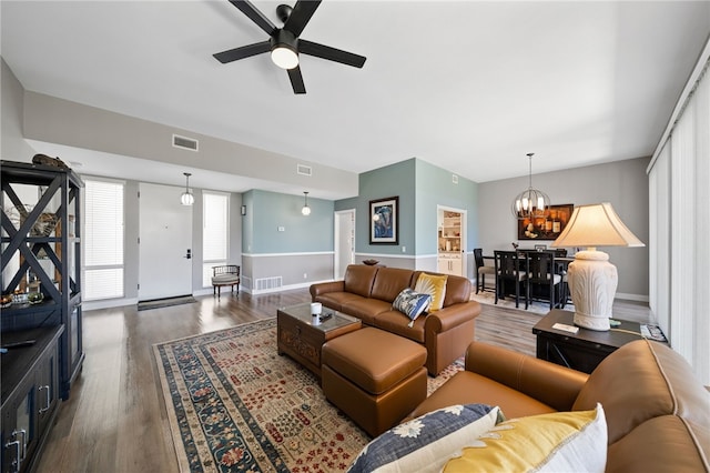 living room featuring ceiling fan with notable chandelier and hardwood / wood-style flooring