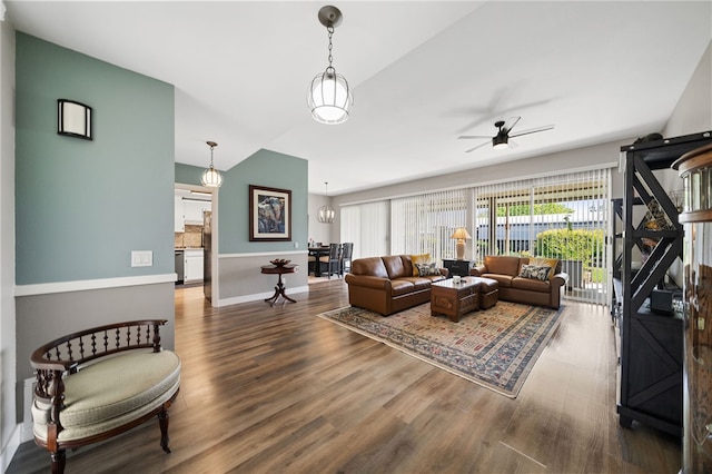 living room with ceiling fan with notable chandelier and wood-type flooring