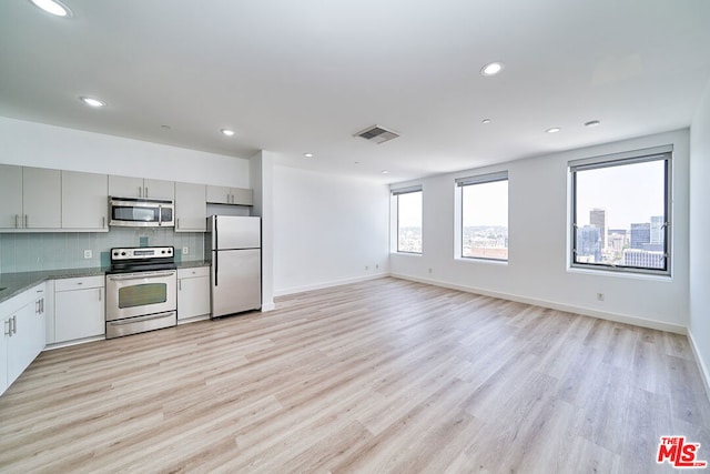 kitchen featuring a healthy amount of sunlight, light hardwood / wood-style floors, appliances with stainless steel finishes, and gray cabinetry