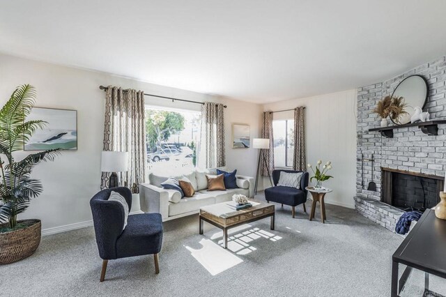 carpeted living room featuring brick wall and a brick fireplace