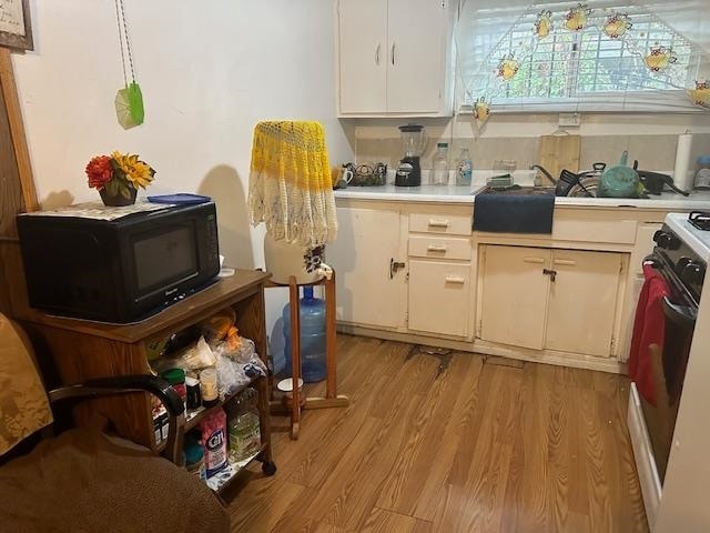 kitchen with light hardwood / wood-style flooring and range with electric cooktop