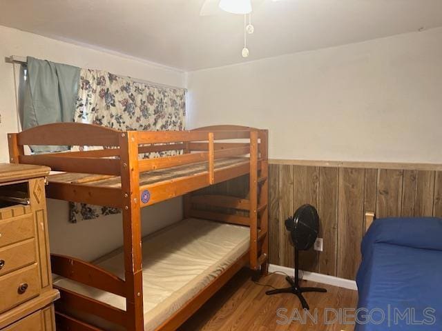 bedroom with dark hardwood / wood-style flooring and ceiling fan