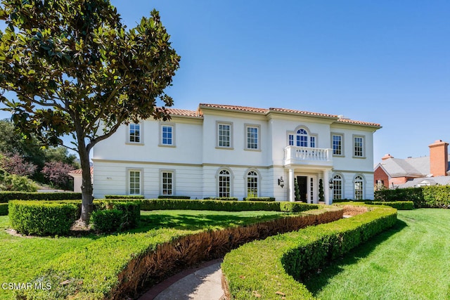 mediterranean / spanish-style house with a balcony and a front yard