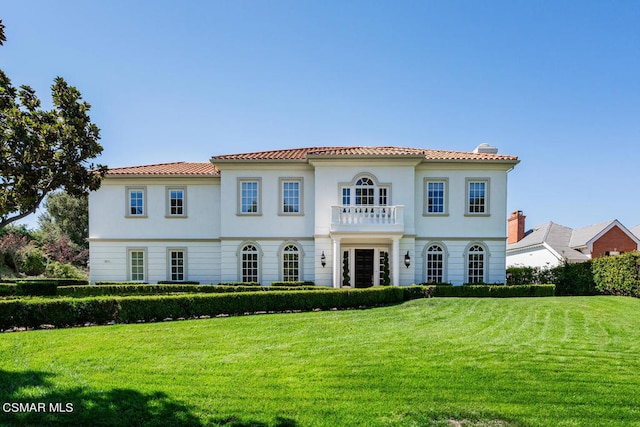 mediterranean / spanish-style house with a balcony and a front yard