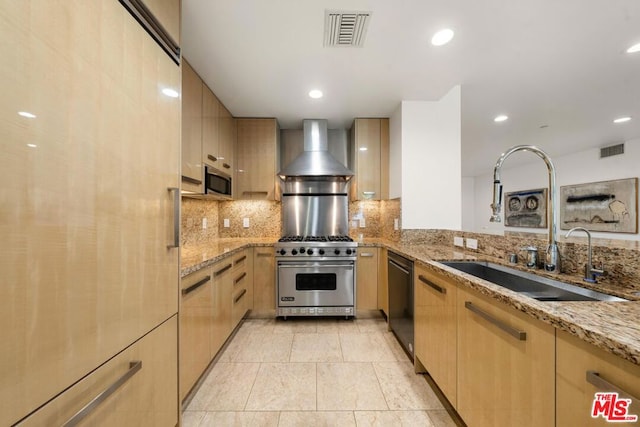 kitchen featuring light brown cabinets, wall chimney exhaust hood, sink, light stone counters, and stainless steel appliances