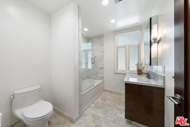 full bathroom with shower / bath combination with glass door, vanity, and toilet