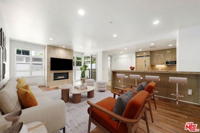 living room with light hardwood / wood-style floors and a tiled fireplace