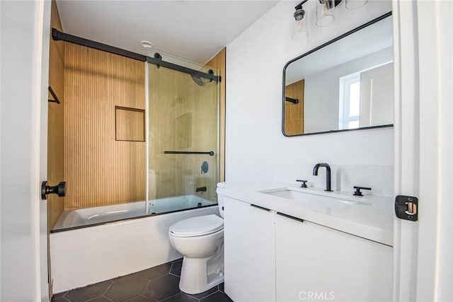 full bathroom featuring tile patterned floors, toilet, combined bath / shower with glass door, and vanity